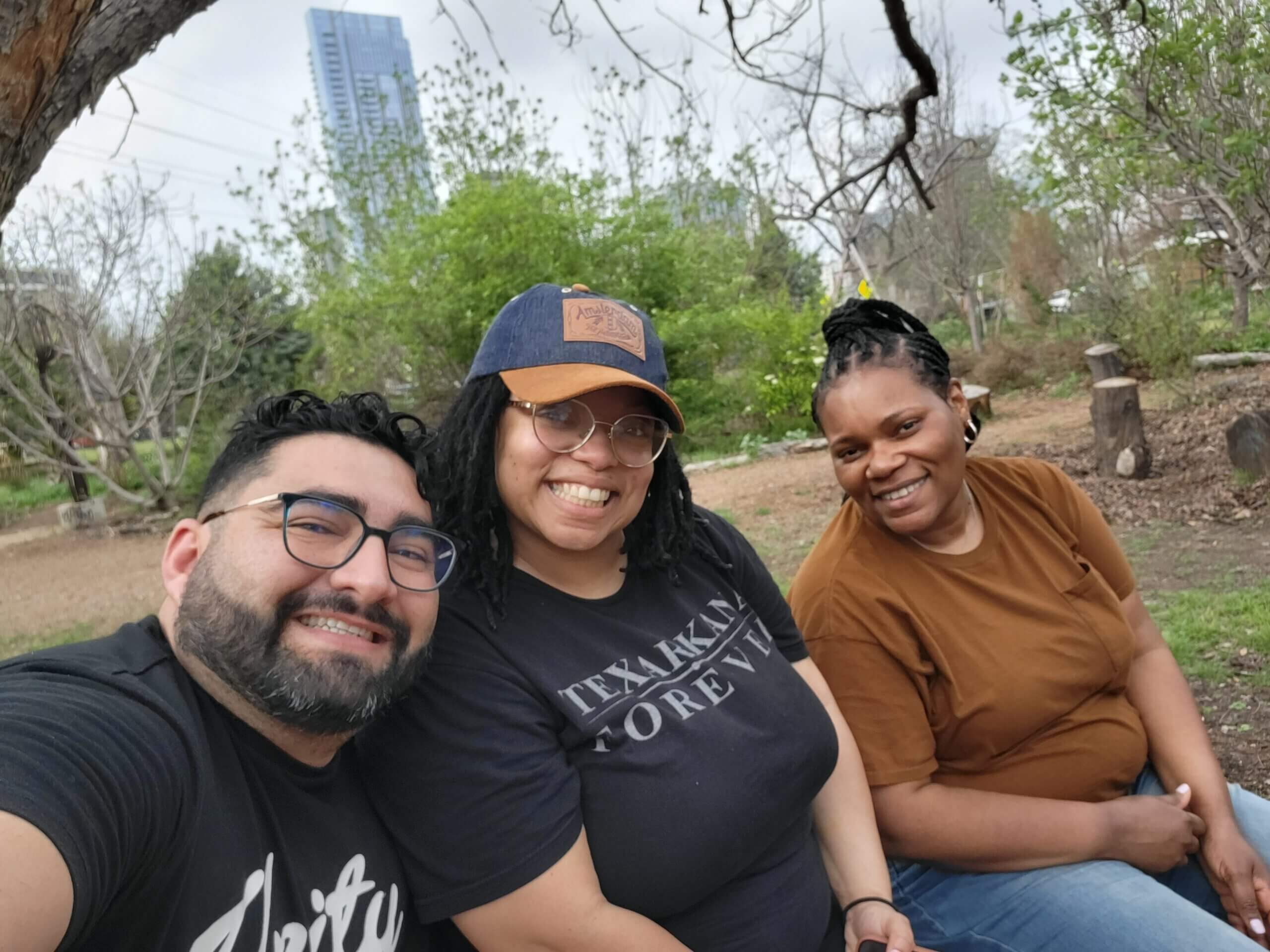 Daniel Parada, Karmella Green, Jamillah Renard take a selfie in front of greenery