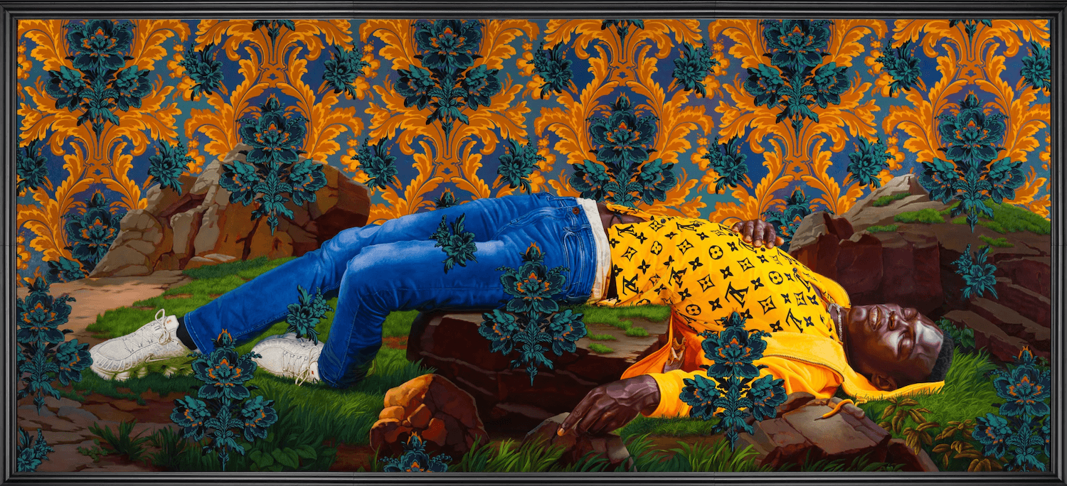 A black man in blue jeans and a yellow sweatshirt lies with his eyes closed over a large rock. An intricate pattern of oranges and blue-greens rises from behind the foreground.